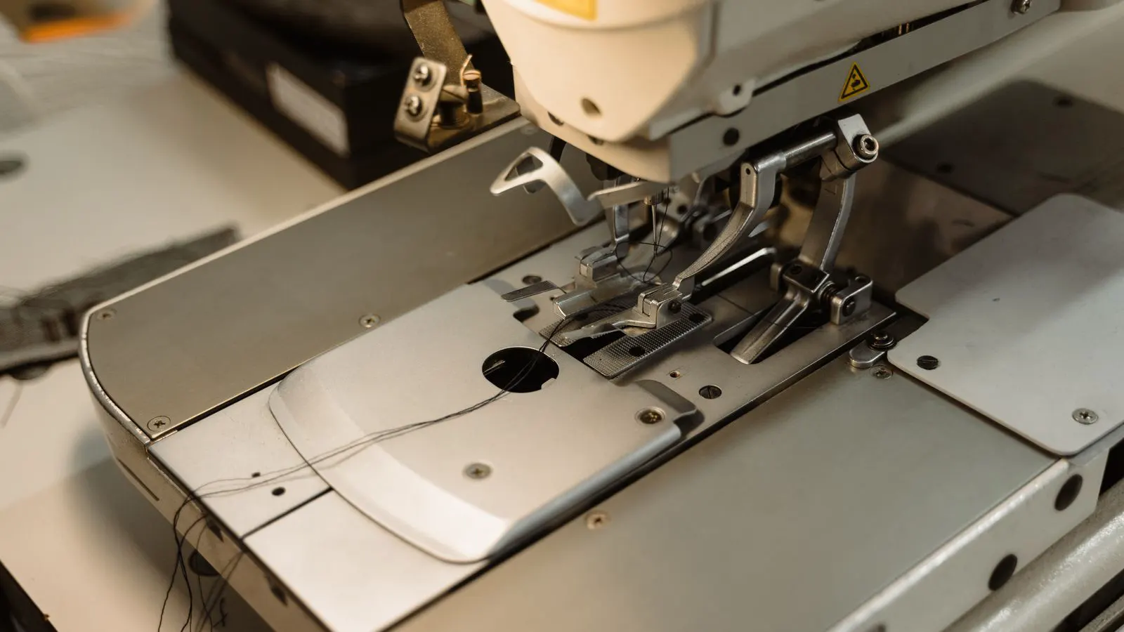 Close view of a heavy duty lockstitch machine sewing thick denim cloth.