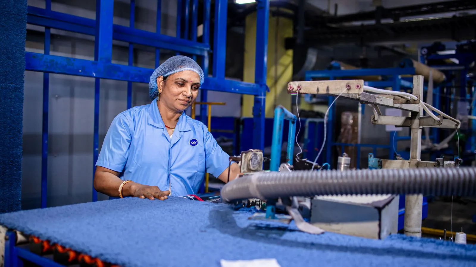 A vision system camera mounted above a moving fabric roll