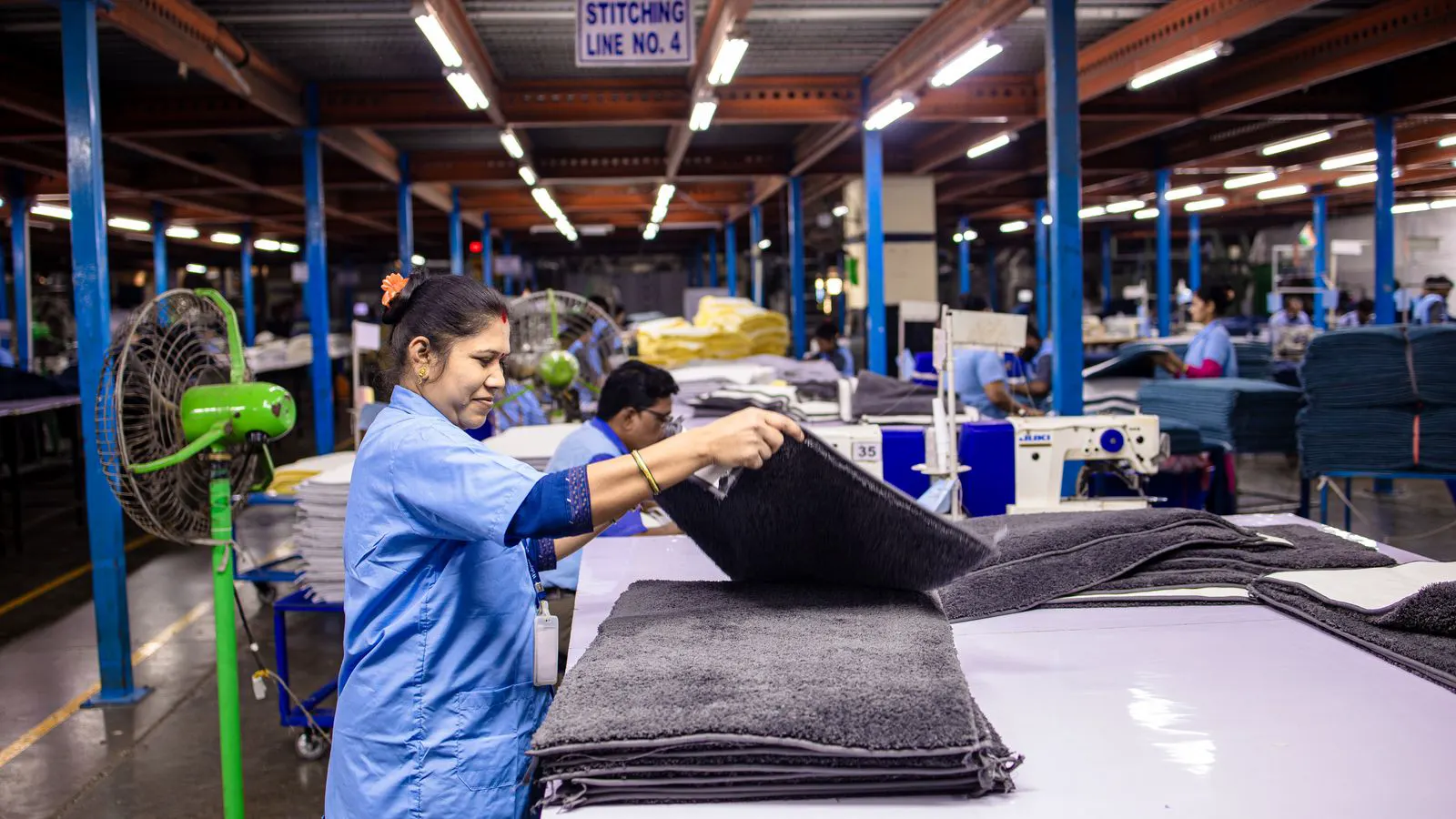 A clean factory floor showing separate sewing stations connected by flexible power drops.