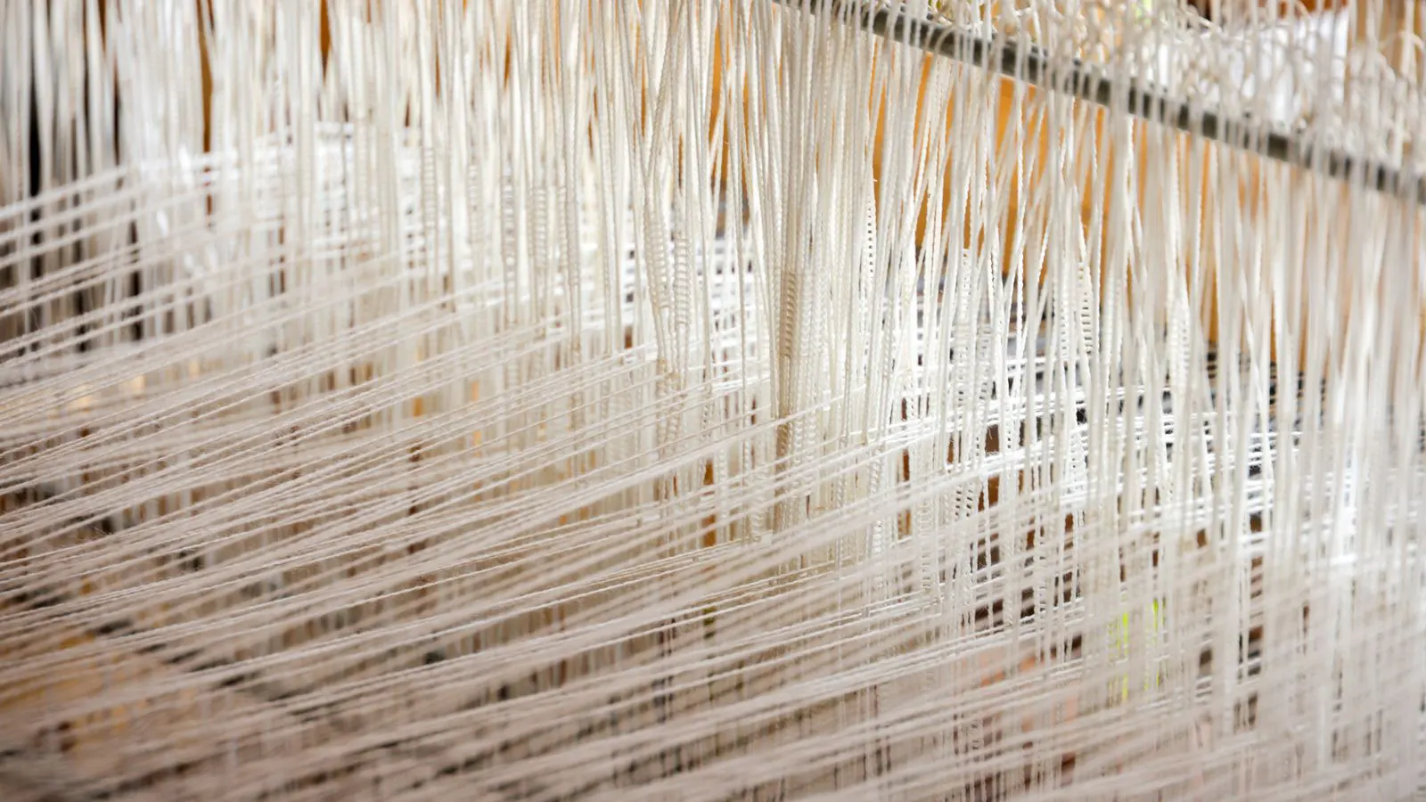 A technician checks a textile loom control panel during maintenance.