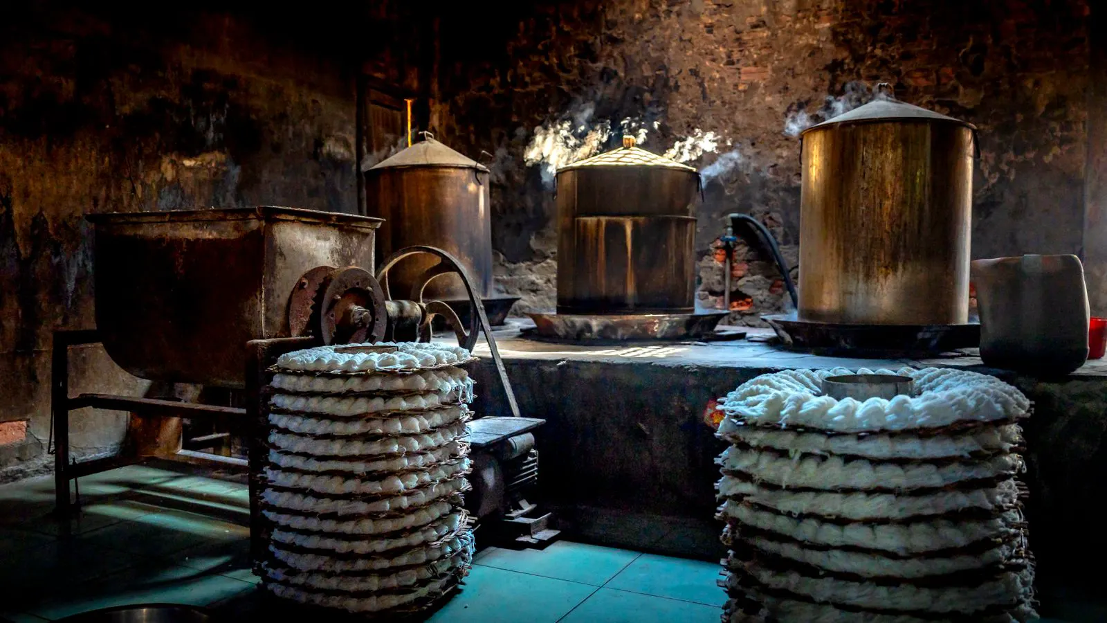 A modern industrial dyeing machine processing fabric in a textile plant