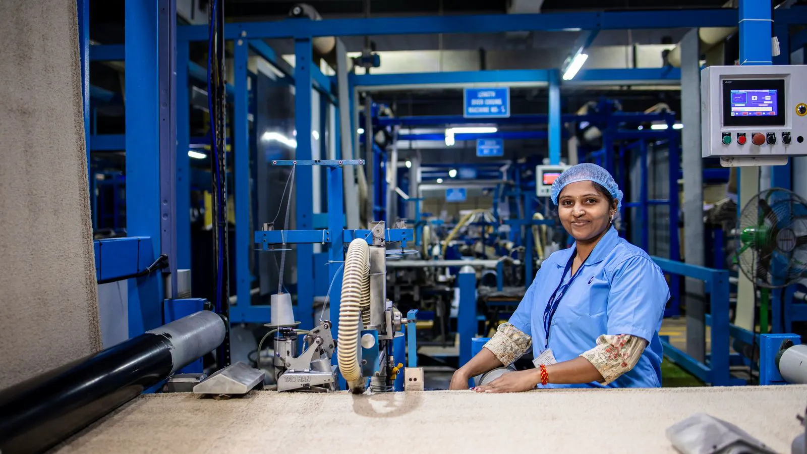 A long row of modern spinning frames in a clean factory hall