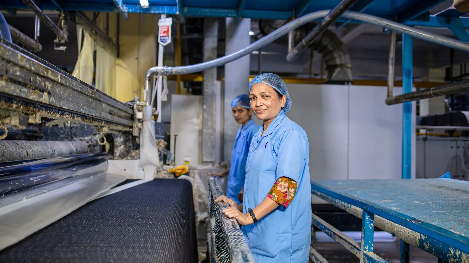 A professional textile dyeing machine with fabric running through the dye bath