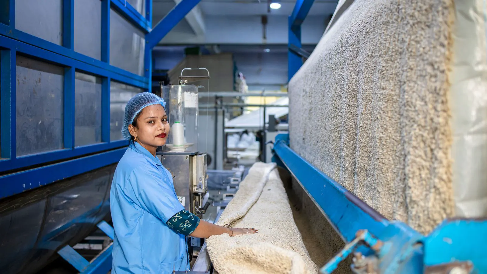 Operators inspecting loom components on a production floor.