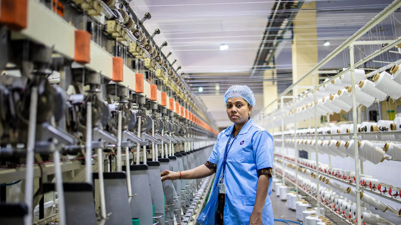 A clean industrial floor with a large spinning machine and control panels.