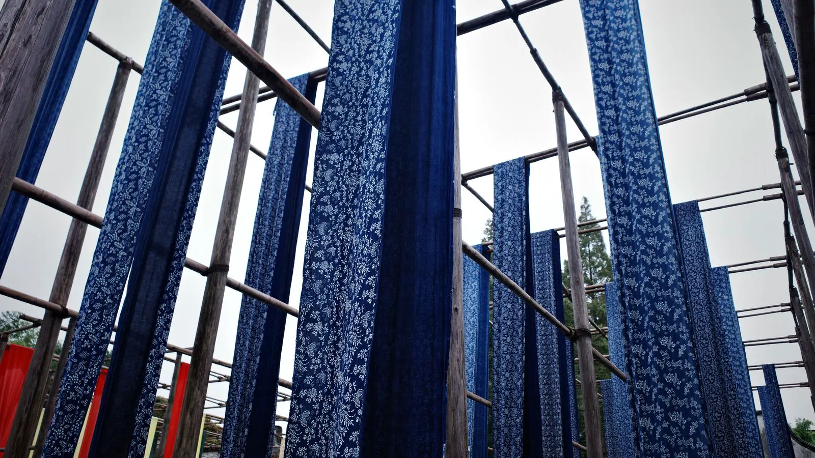 Large steel dyeing vats filled with blue dye in a factory