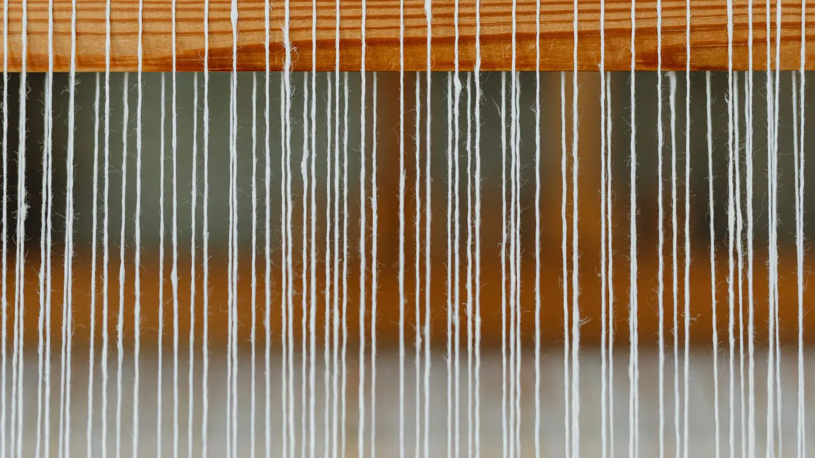 Technician adjusting warp tension on a power loom