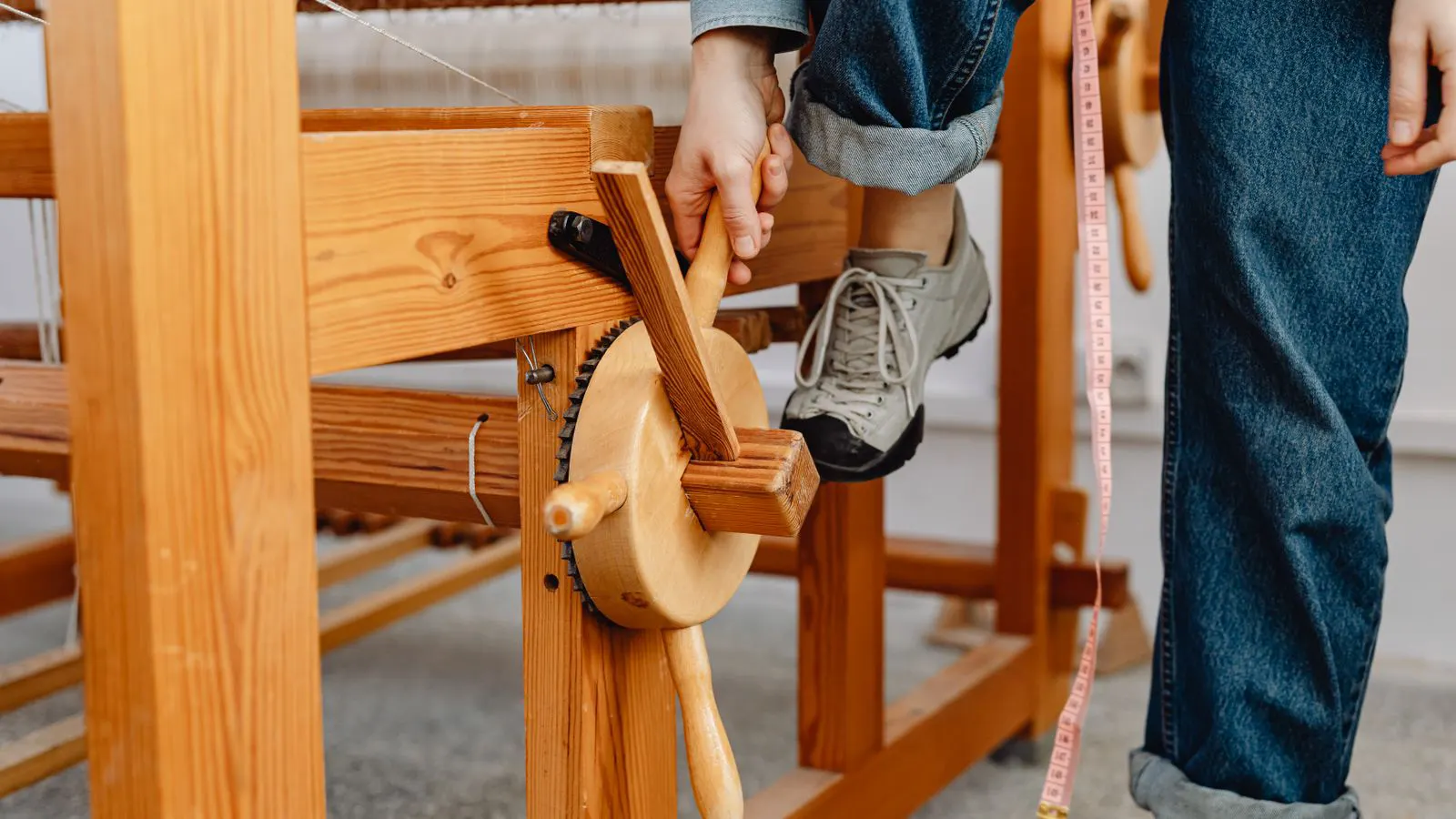 Technician checks warp tension on a modern power loom