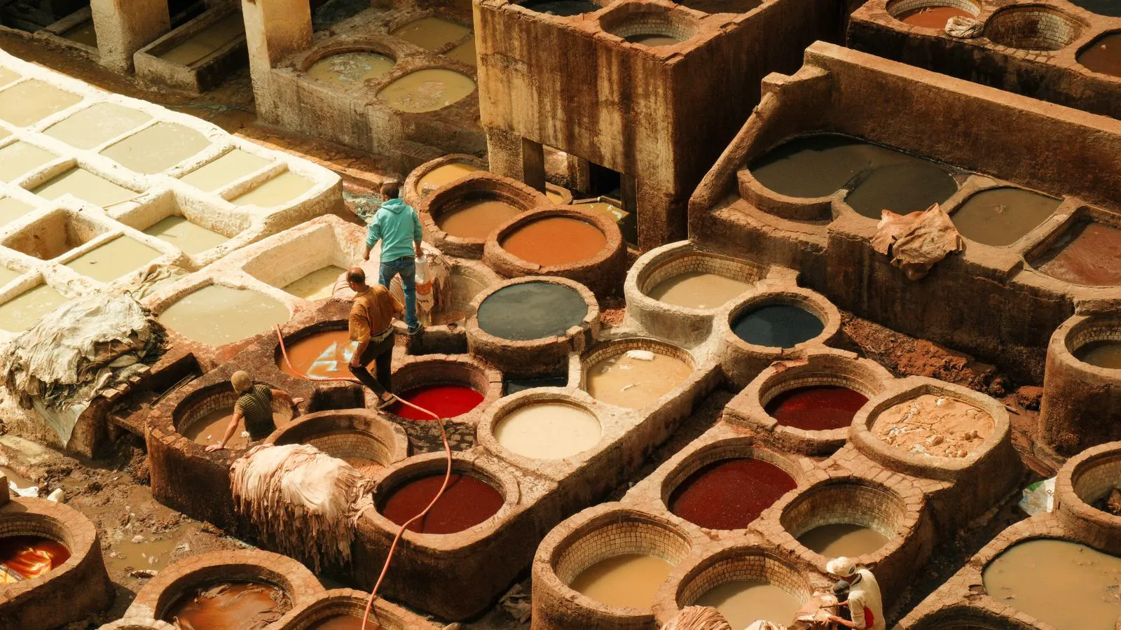 A modern industrial textile plant with large steel dyeing vats and piping.