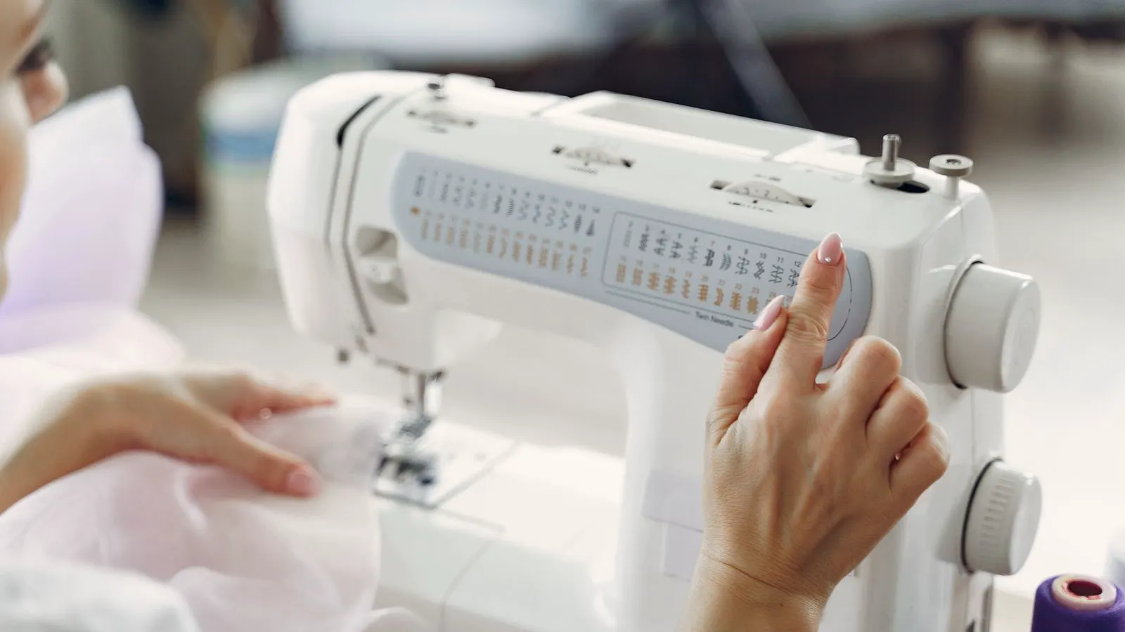 A close-up view of a sewing machine control panel with indicator lights