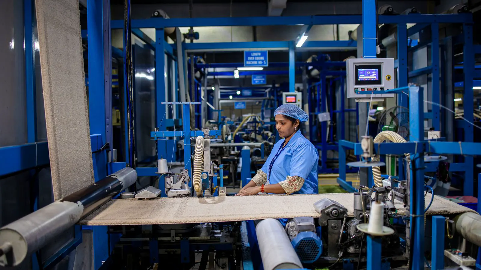 A technician installing a new servo motor on a power loom frame.
