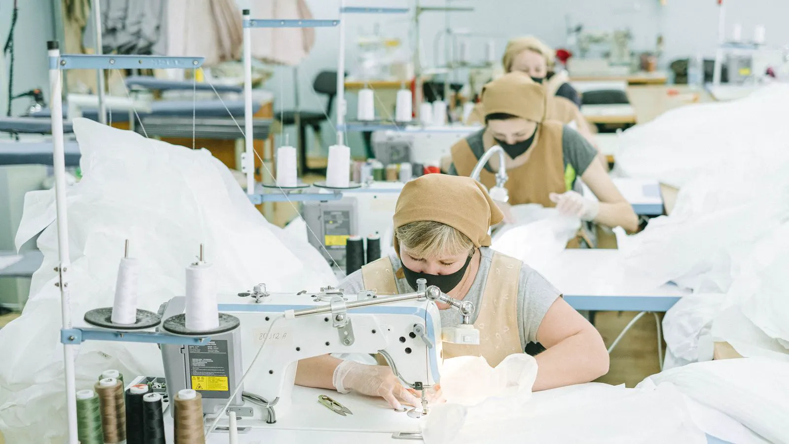 Two industrial sewing machines set up in a garment workshop