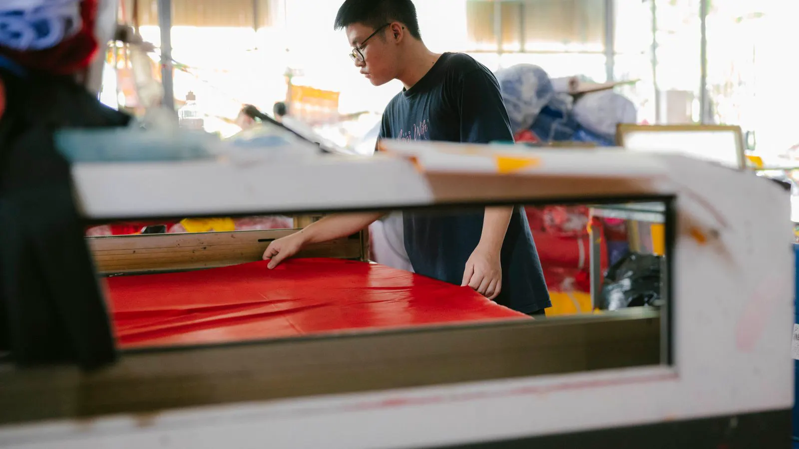 A long fabric roll passing through a machine with multiple cameras and sensors.