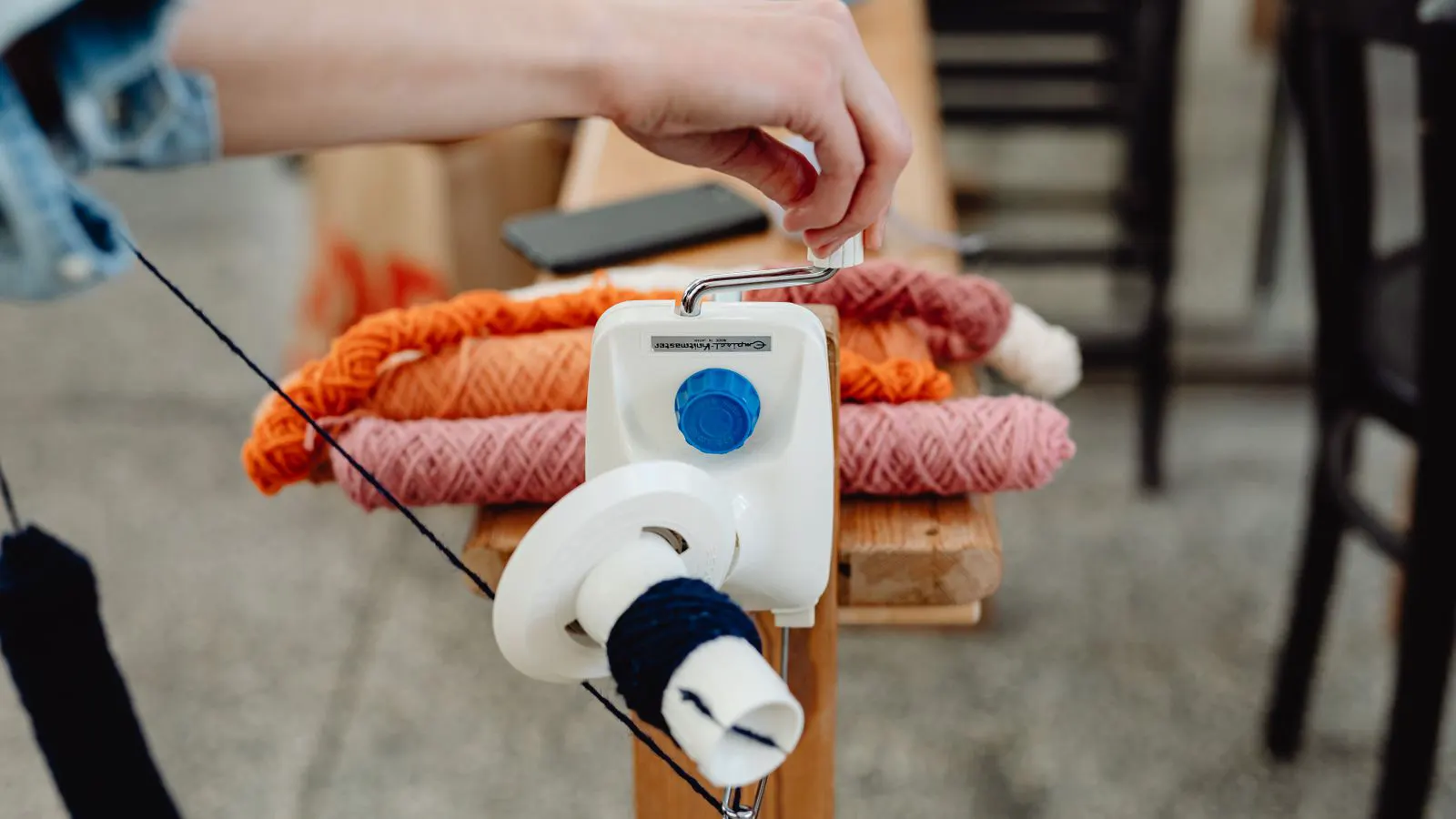 Technician adjusting tension knob on yarn feed unit