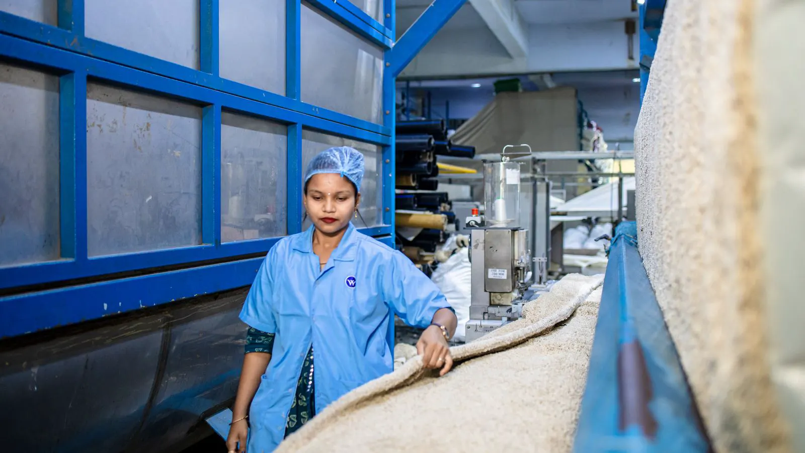Automated fabric inspection machine inspecting textile rolls in a factory.