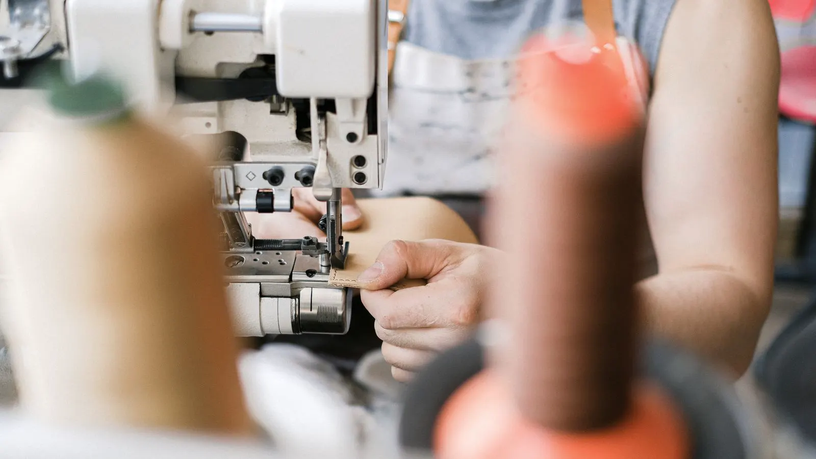 Industrial sewing machine with a leather strap on the needle bar
