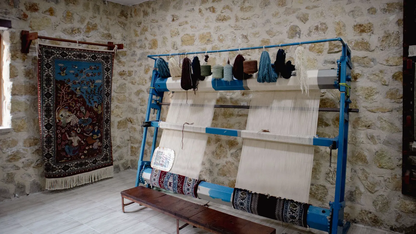 A control panel with indicator lights connected to a woven fabric shuttle