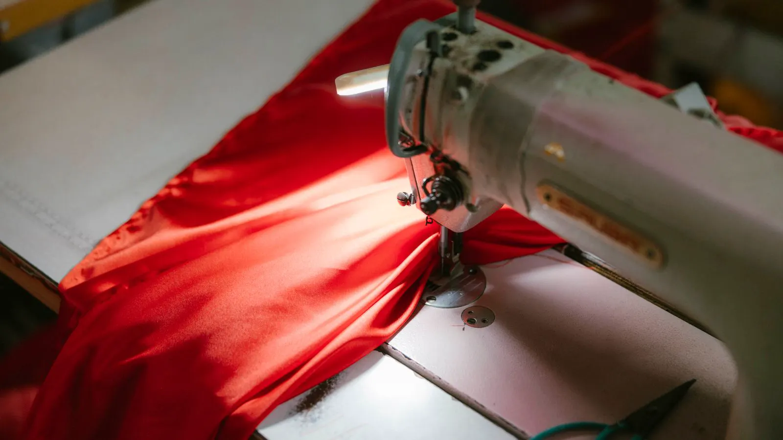Industrial overlock machine processing raw fabric edges with thread