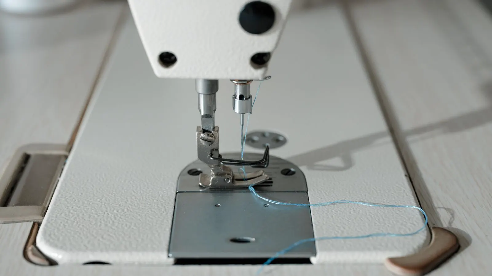 A thick industrial power cable connecting to an electrical panel near a sewing machine.