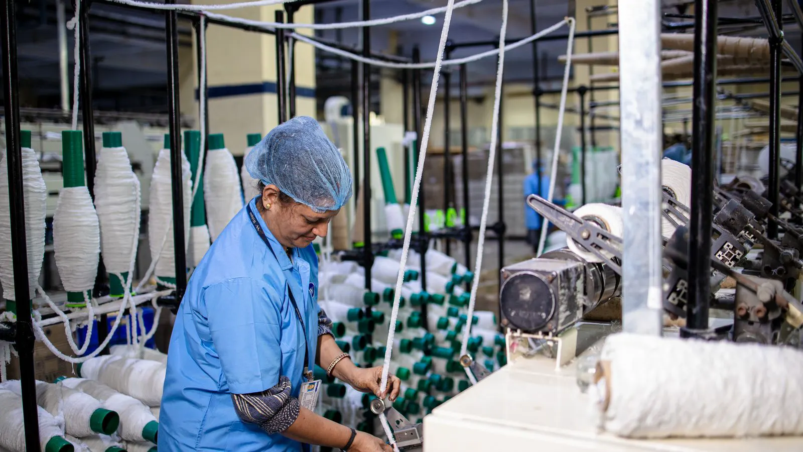 A textile factory floor with rows of industrial knitting machines.
