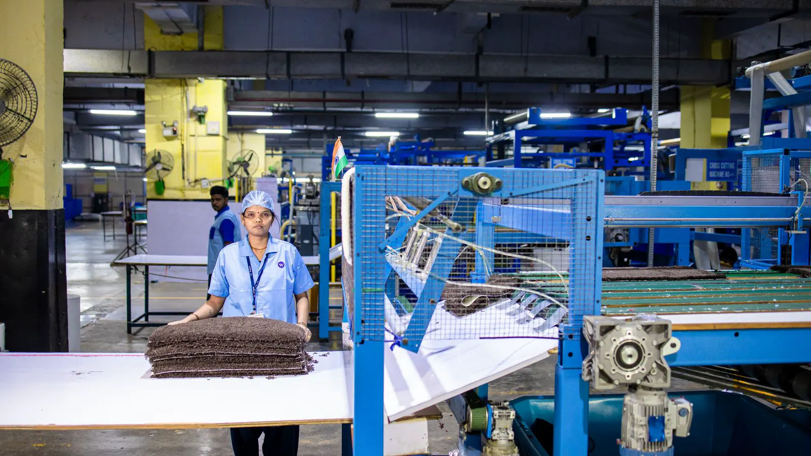 Modern factory floor with connected textile machines and control screens