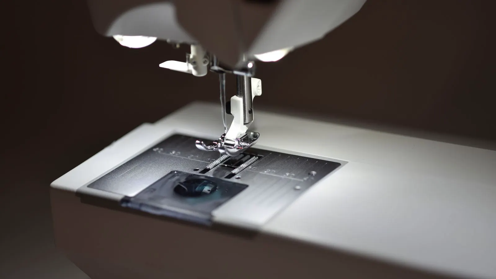Close up of a presser foot on an industrial sewing machine.