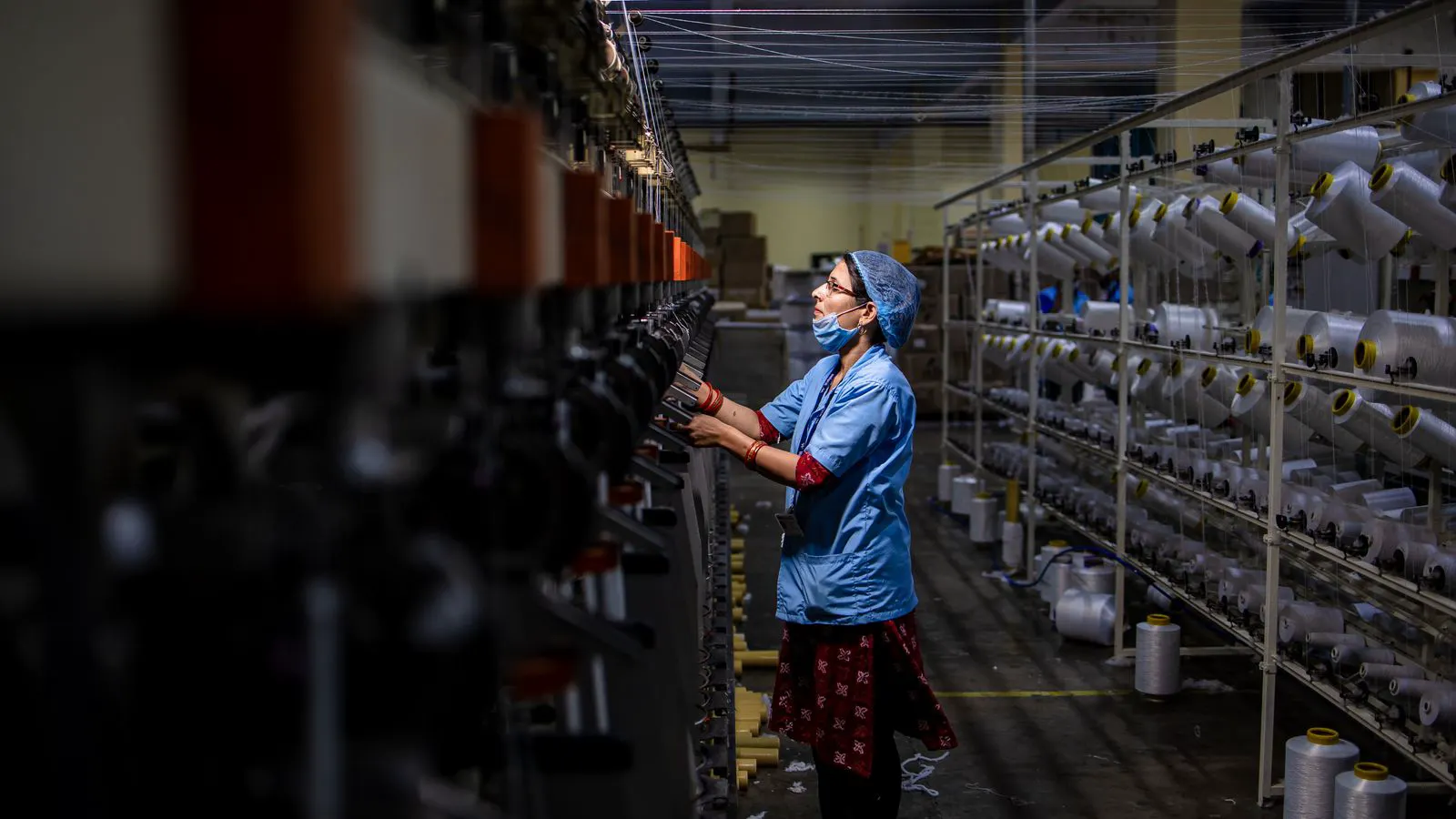 An engineer checking the tension on a power loom belt