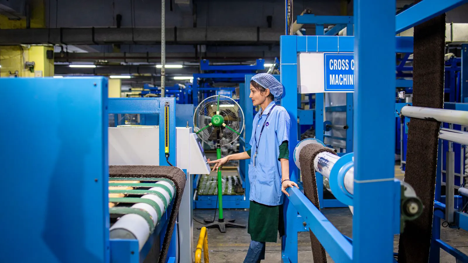 A large dyeing machine with a water inlet pipe and tank in a textile factory.
