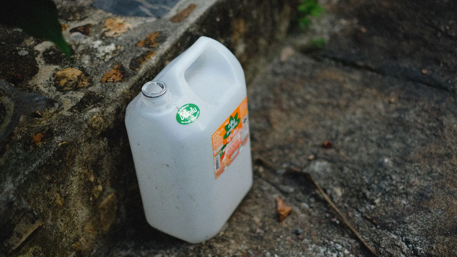 A clear container filled with white plastic resin granules on a table