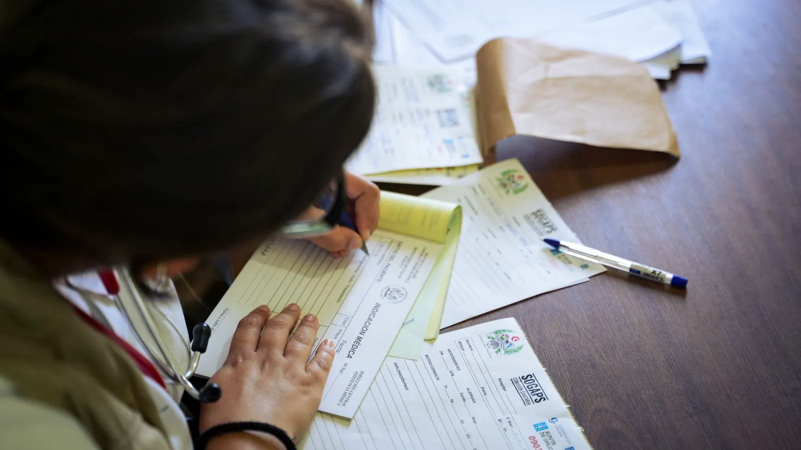 A clipboard with a checklist next to a stack of technical papers.