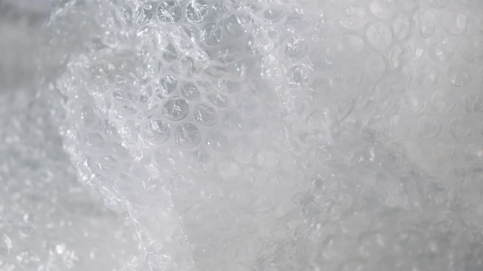 White and black resin pellets near an open injection molding machine