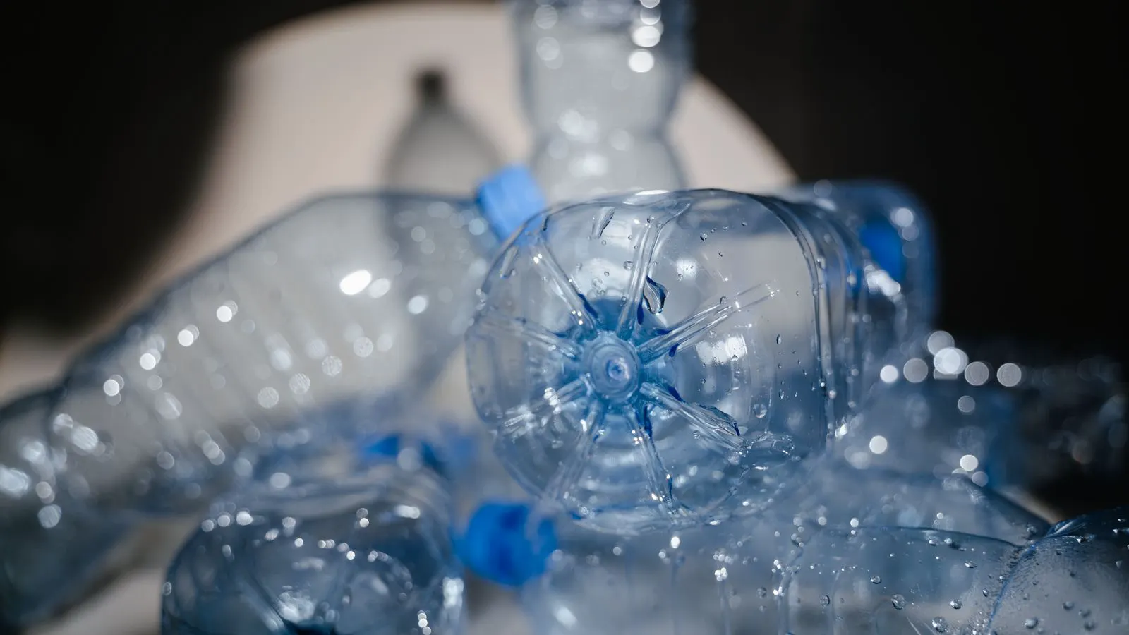 A close up of clear plastic pellets inside a machine hopper