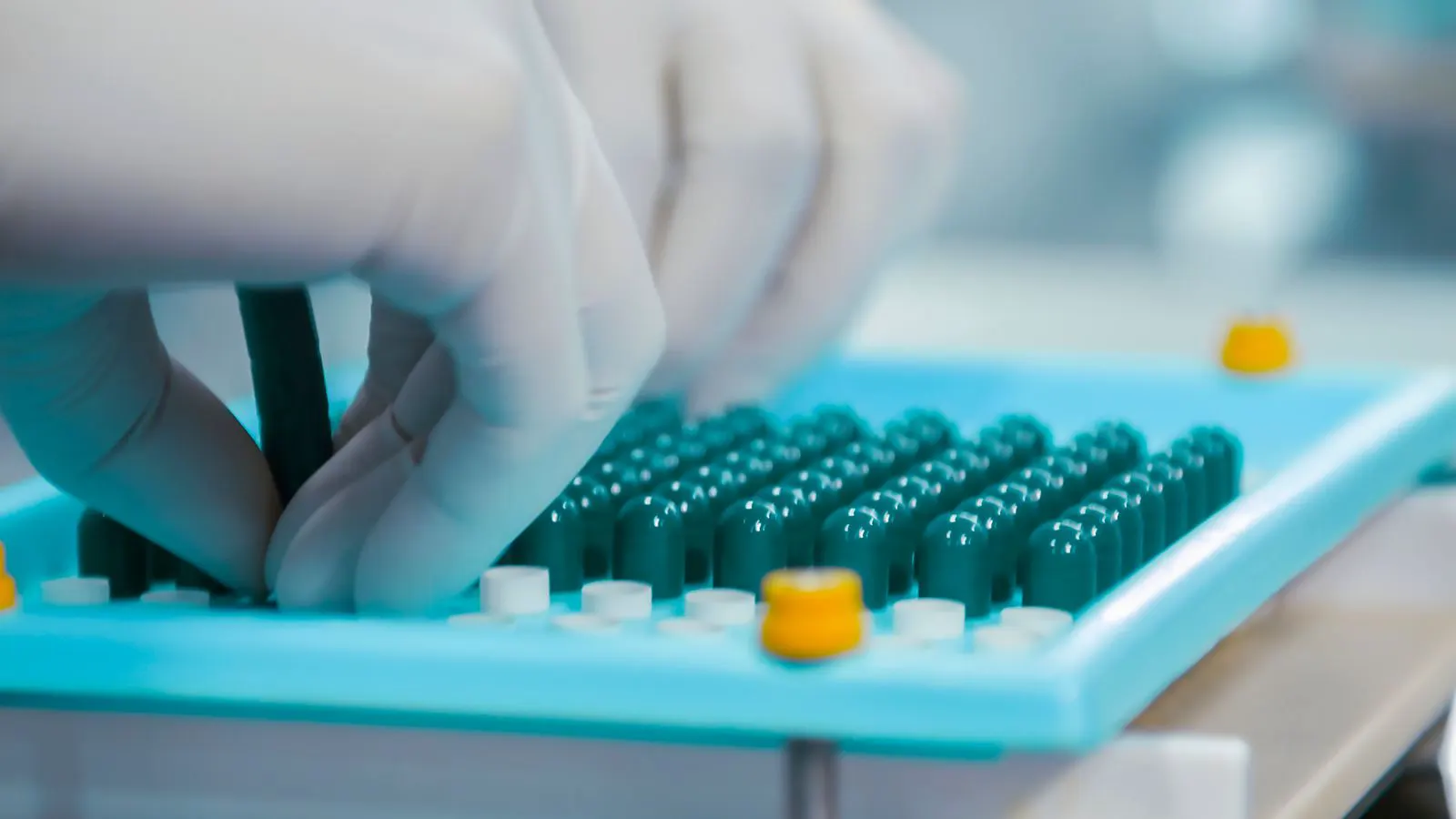 A technician reviewing molded plastic parts in a manufacturing quality lab.