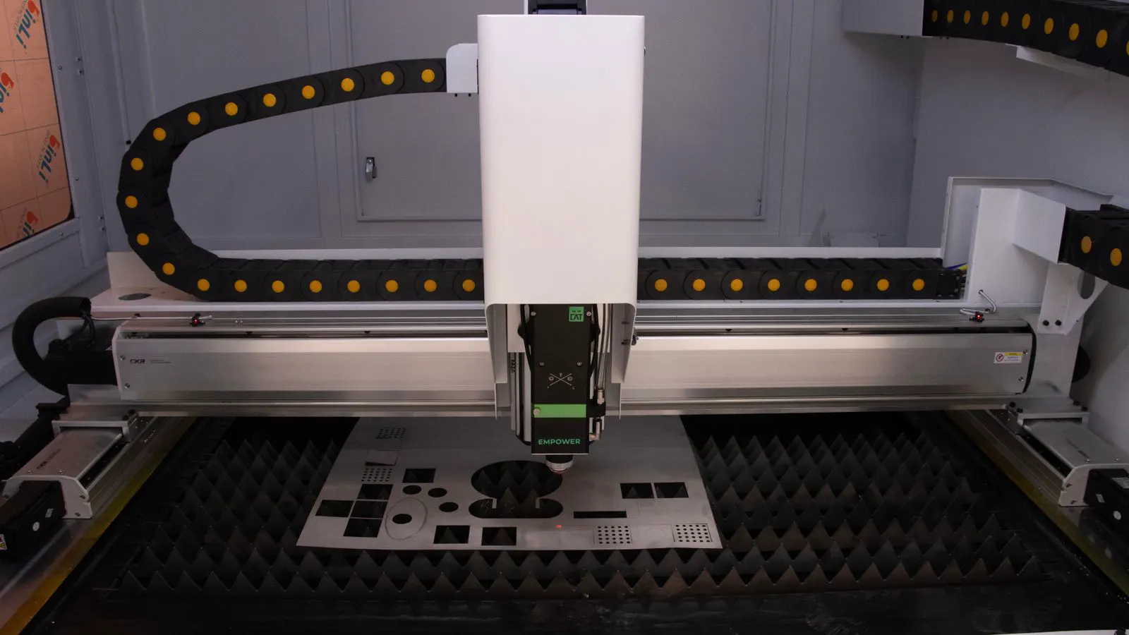 Close view of metal sheets undergoing laser and plasma cutting operations.