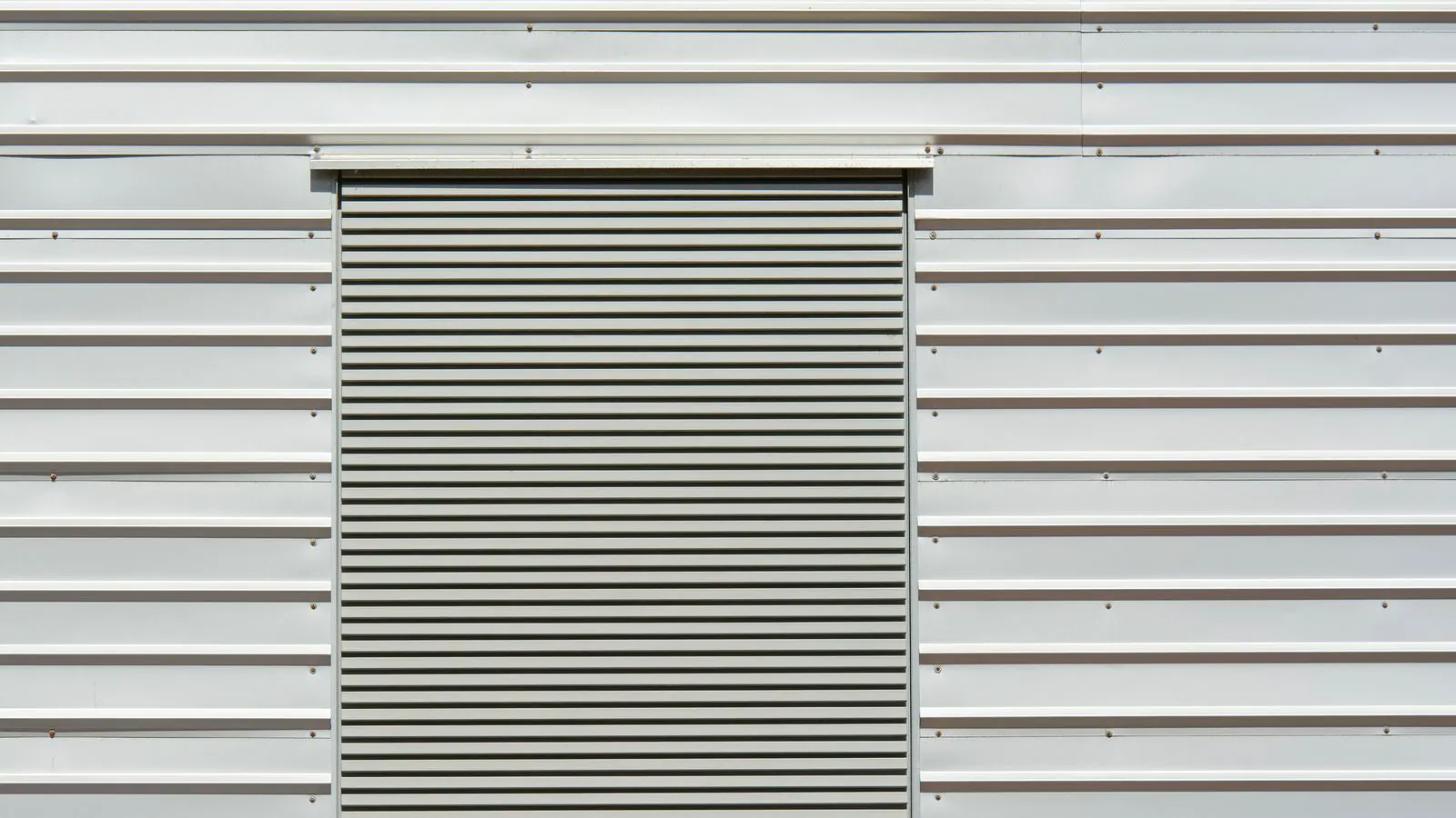 A close up view of raw aluminum sheet metal in a factory.