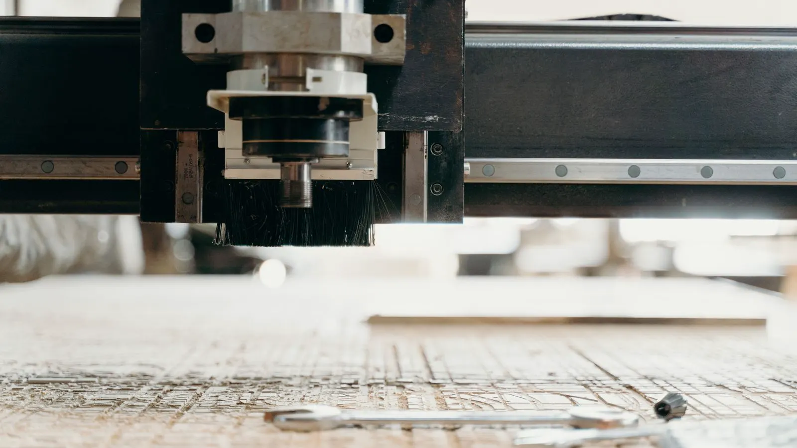 A machinist checks a sheet metal bracket on a CNC mill.