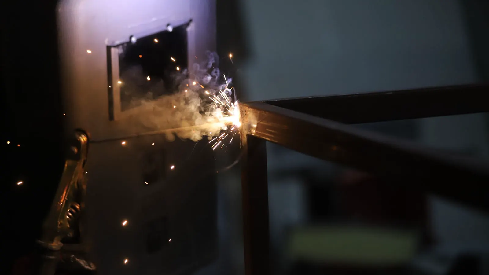 Technician examining a weld bead on a sheet metal part