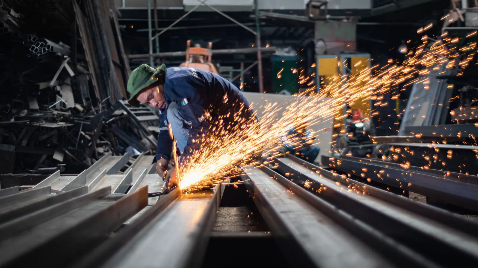 A professional inspector checking sheet metal parts on a production floor.