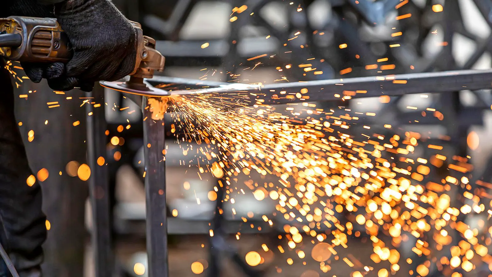 A worker inspecting a sheet metal assembly in a workshop