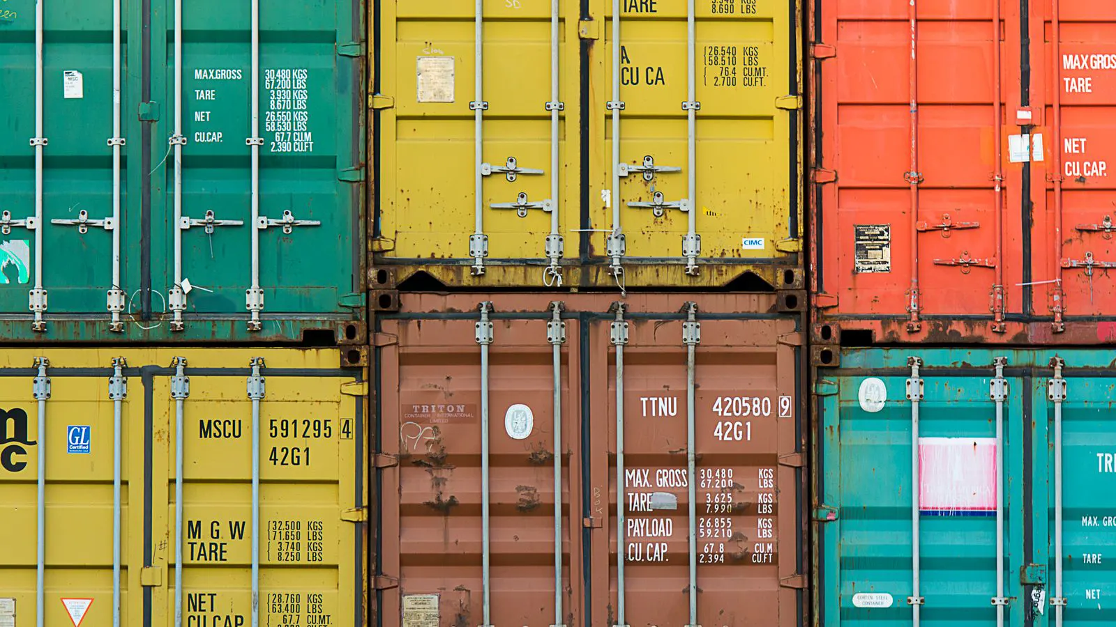 A container ship loading metal boxes at a port facility