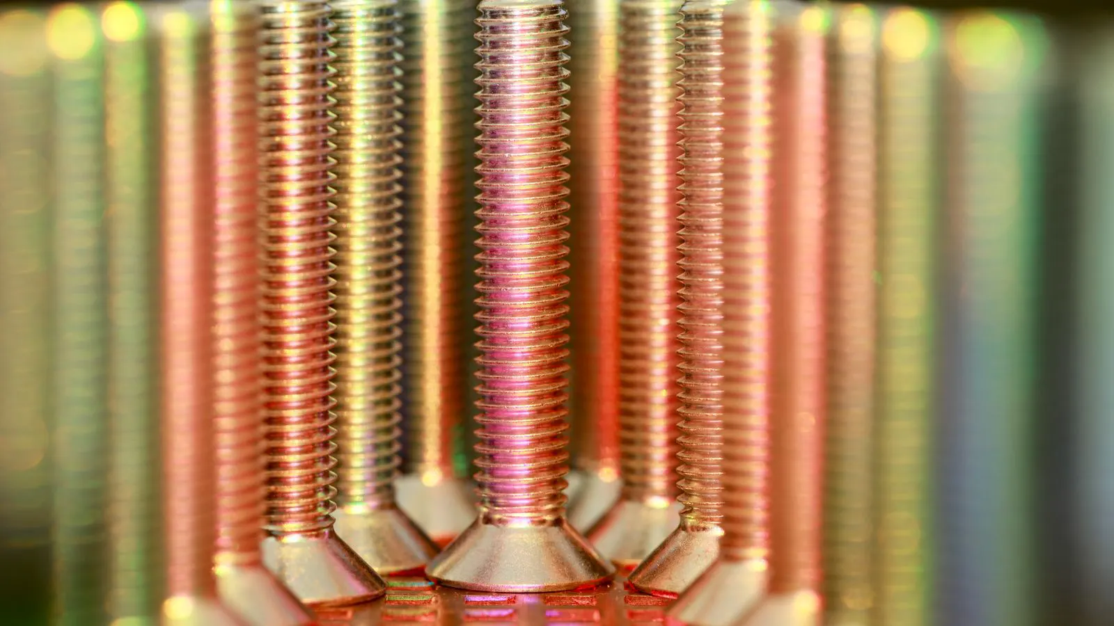 A technician inspecting stamped sheet metal parts under bright light