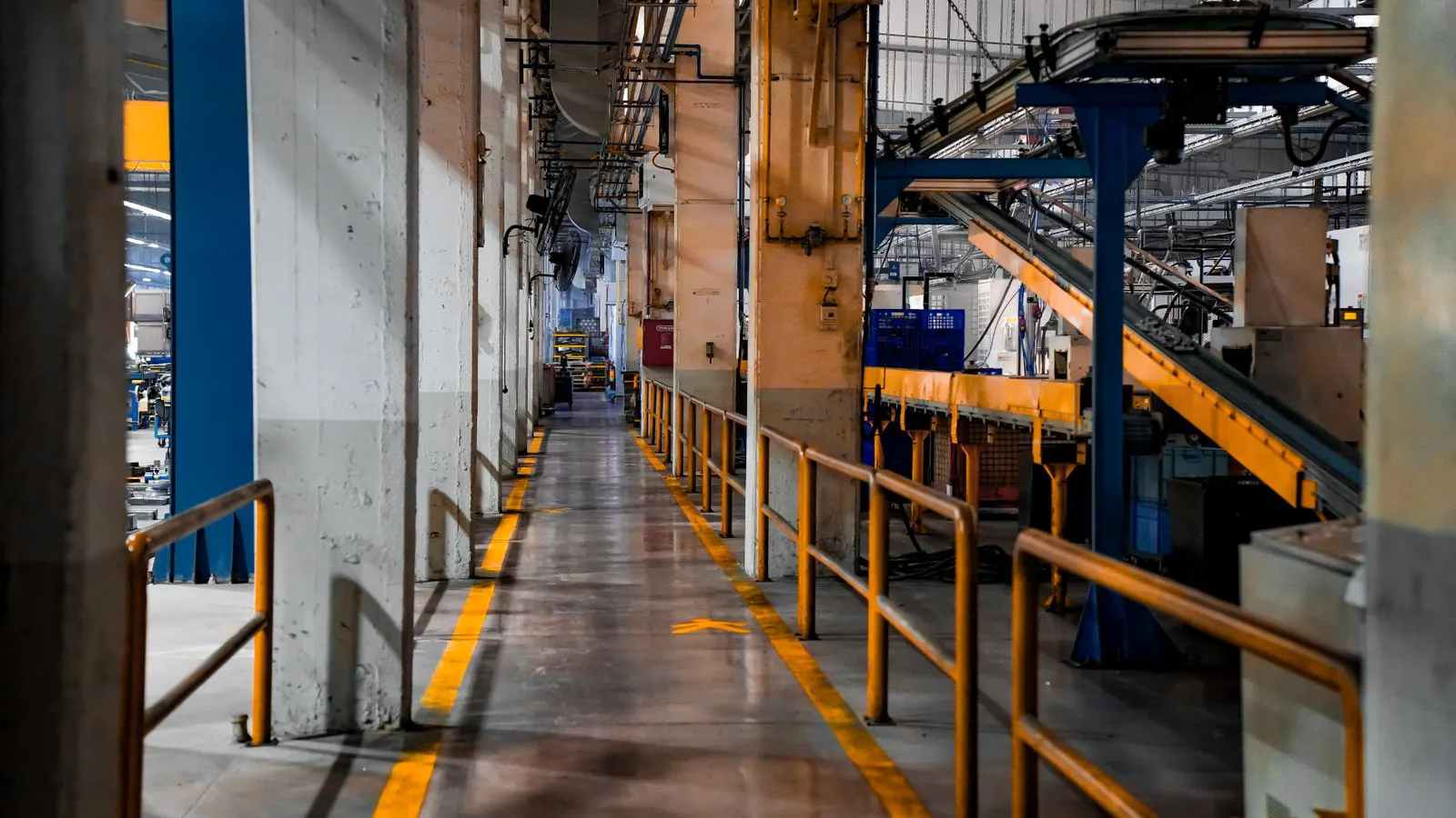 Metal stamping press machines producing sheet metal parts on a factory floor.