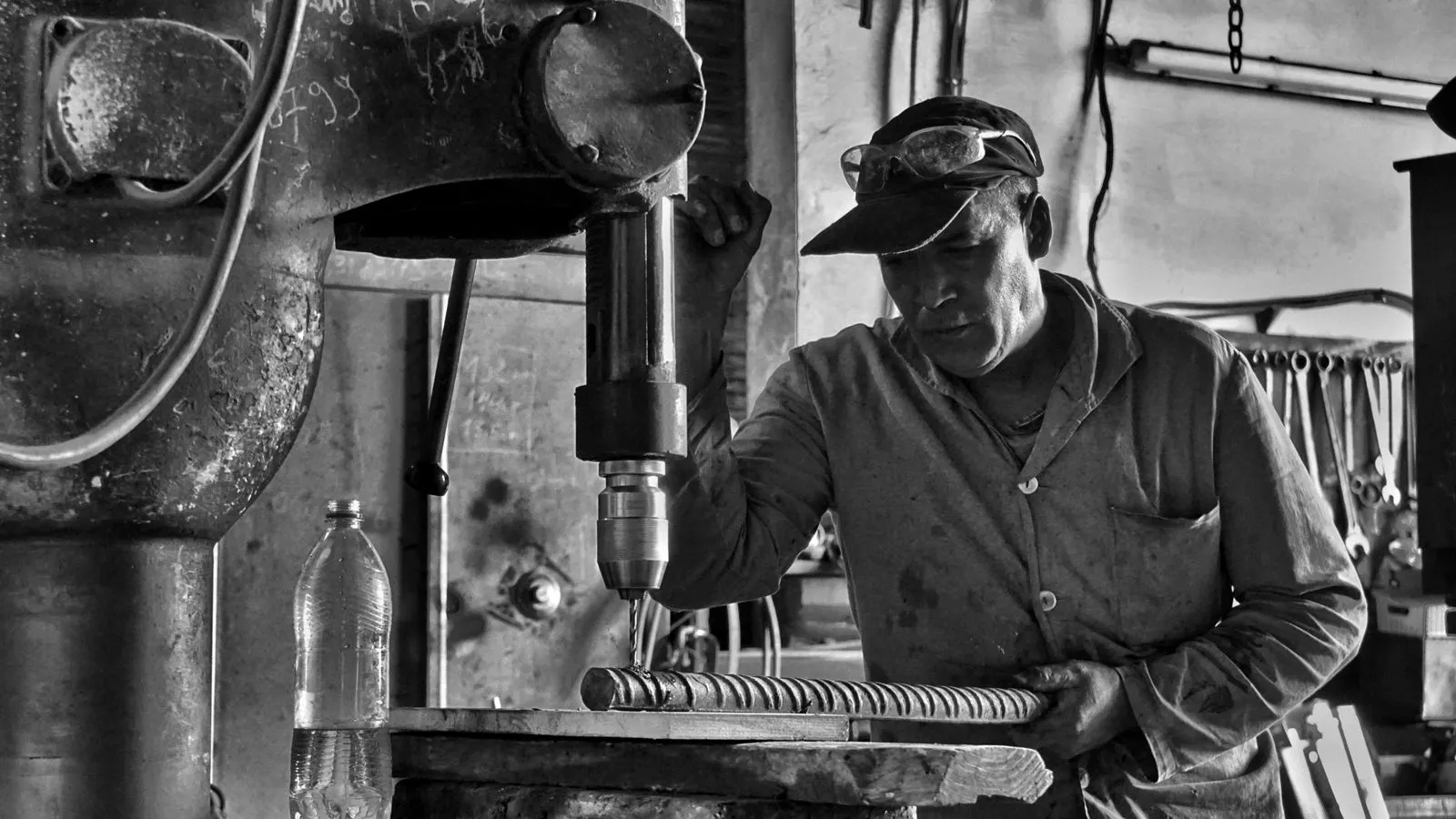 Engineer inspecting a stamped part in a metal stamping facility