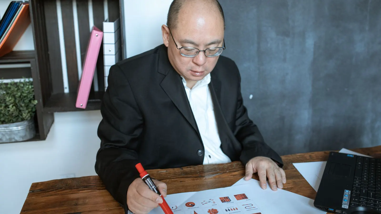 An engineer checks a stamping data sheet on a desk