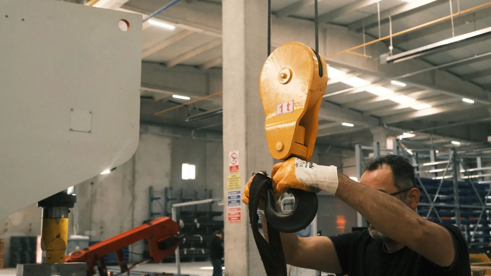 A production worker inspecting stamped metal components under bright light
