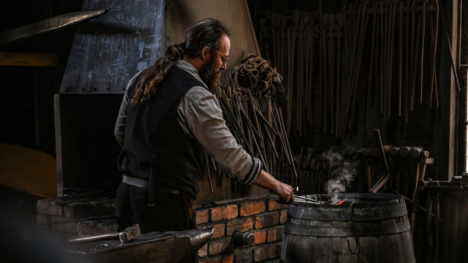 A technician reviewing material certificates next to a stack of forged steel parts