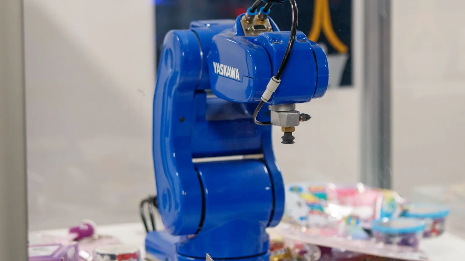 A robotic arm positioned near a heavy forging die in a factory.