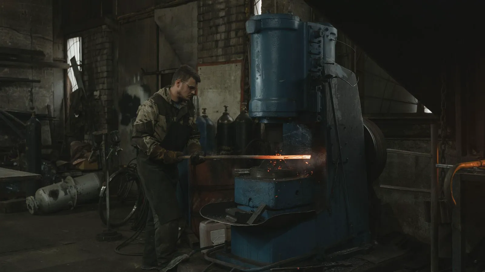 An inspector reviewing forging equipment in a modern workshop
