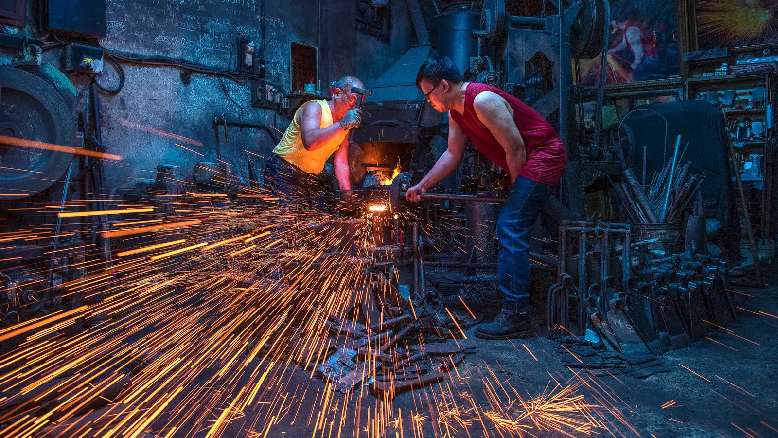 A forging press producing metal flash around a die assembly.
