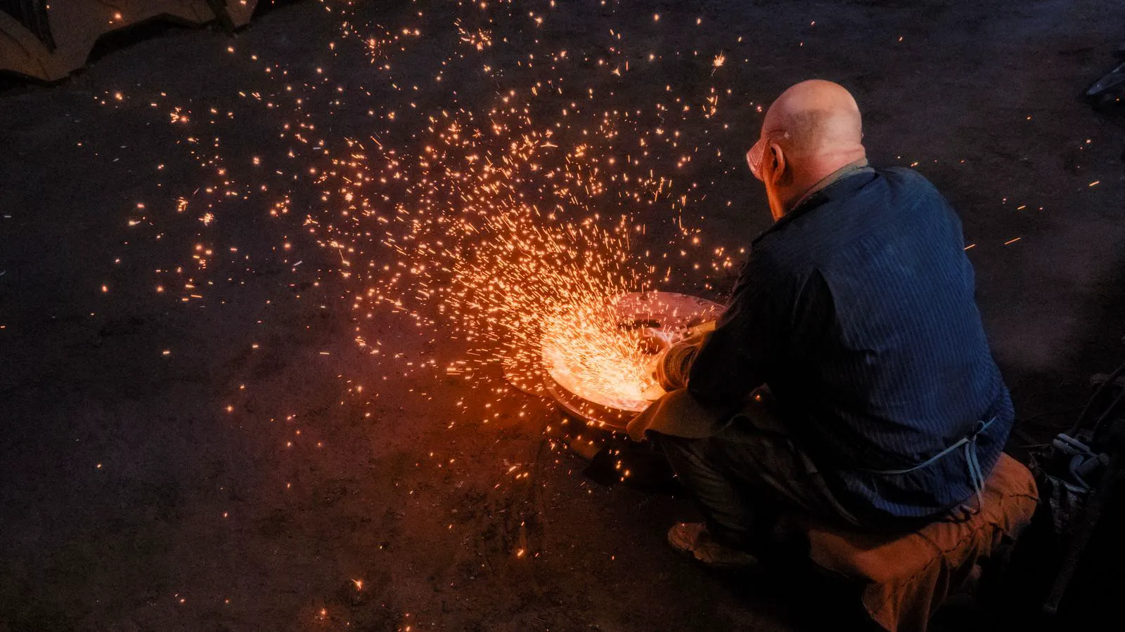 Heavy industrial forging press shaping hot metal in a factory.